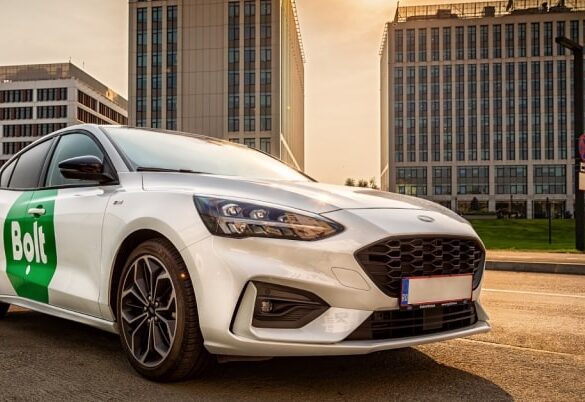 Ford sedan with Bolt logo on door against a cityscape backdrop