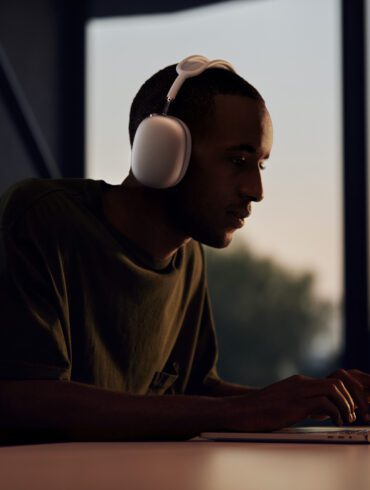 Man waering AirPods Max while working on his MacBook
