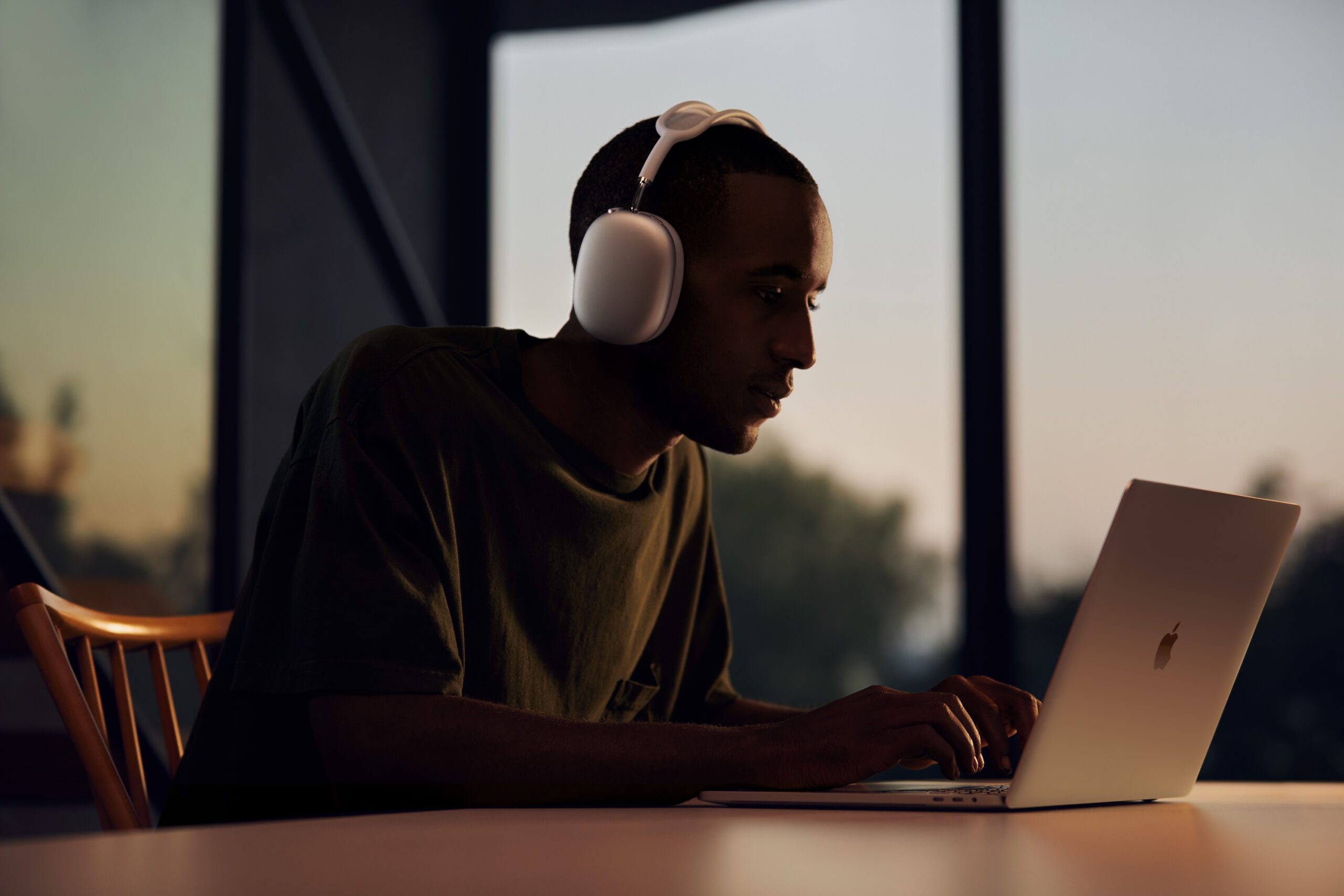 Man waering AirPods Max while working on his MacBook