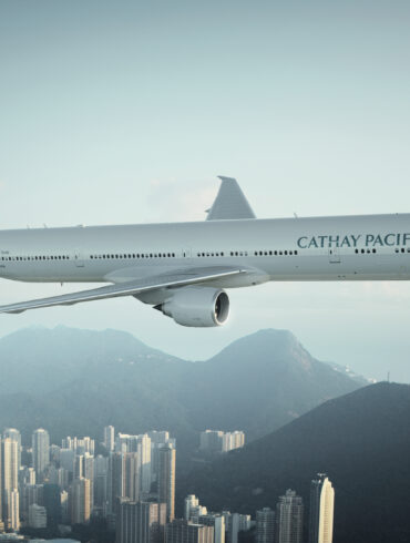 Cathay Pacific aircraft flying above a city