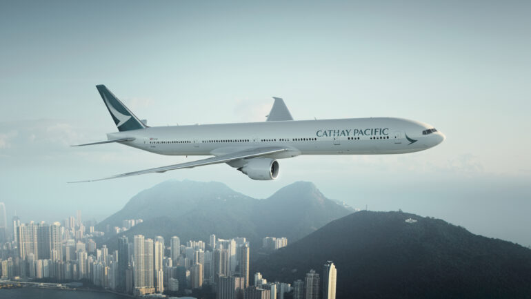 Cathay Pacific aircraft flying above a city