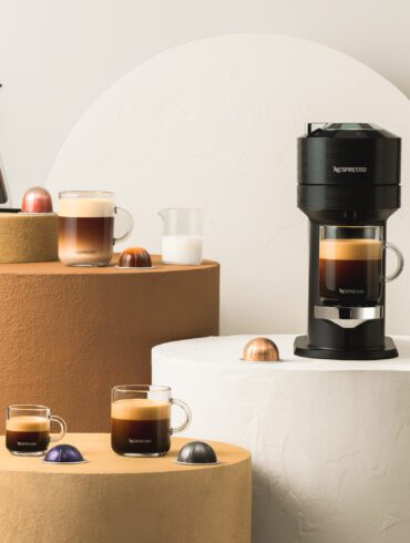 Nespresso Vertuo system and various coffee mugs filled with coffee