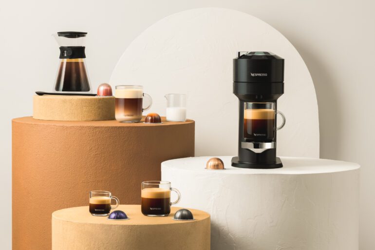 Nespresso Vertuo system and various coffee mugs filled with coffee