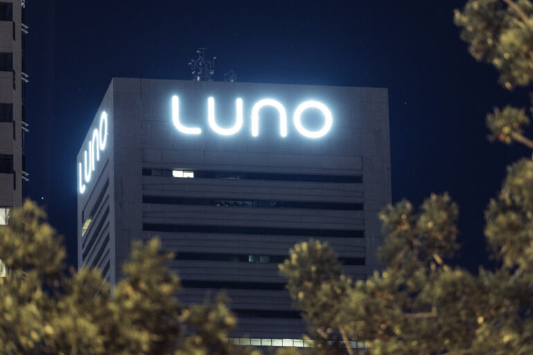 Night time image of LUNO sign on building