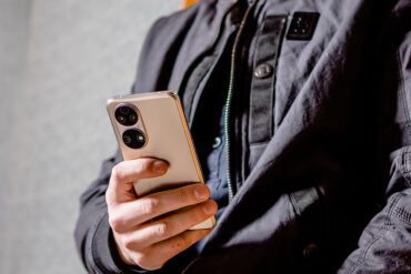 HUAWEI P50 - Lifestyle - Image of a person wearing black clothing holding a gold Huawei P50 in their hand