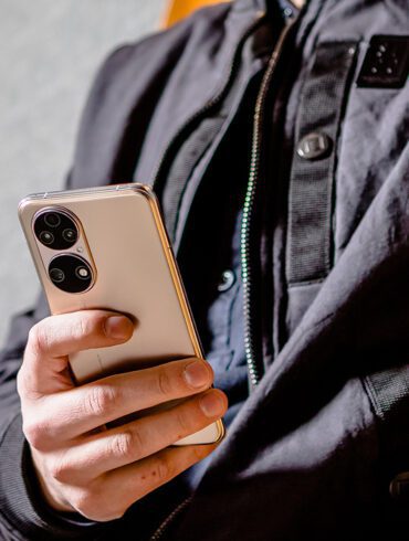 HUAWEI P50 - Lifestyle - Image of a person wearing black clothing holding a gold Huawei P50 in their hand
