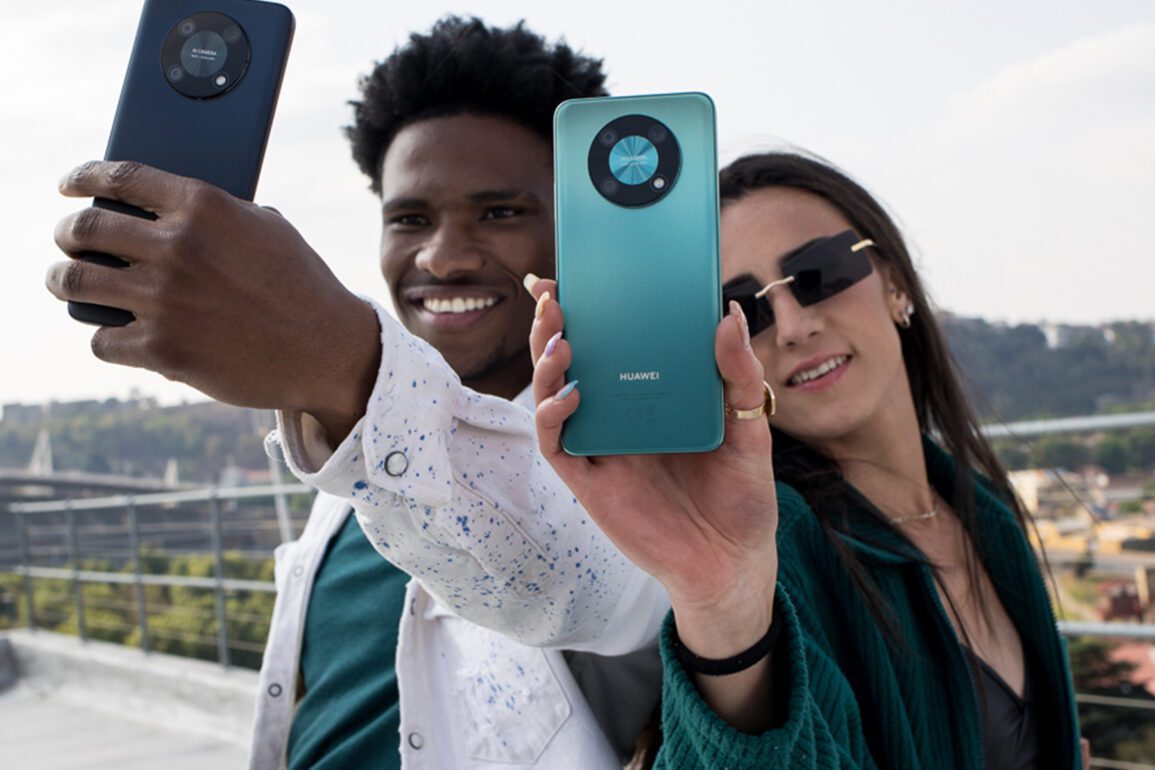 Product image of a man and a woman holding the Huawei nova Y90 outside