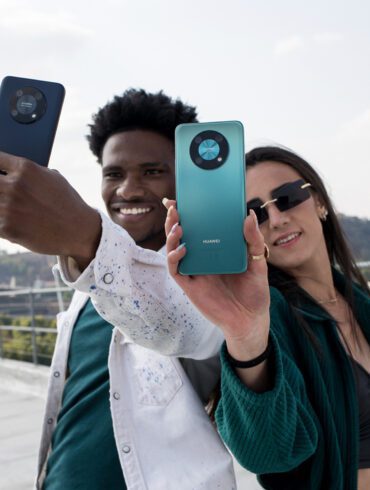 Product image of a man and a woman holding the Huawei nova Y90 outside