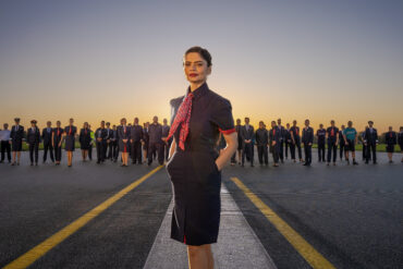 Outdoors group image of various staff members of British Airways wearing the company's new uniform.