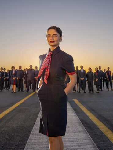 Outdoors group image of various staff members of British Airways wearing the company's new uniform.