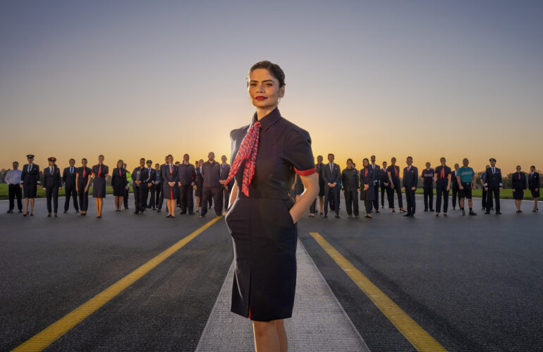 Outdoors group image of various staff members of British Airways wearing the company's new uniform.