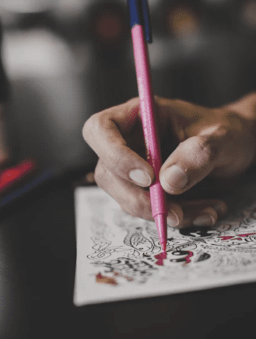 Image of a Han holding a pencil drawing something for the Red Bull Doodle competition.