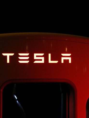close-up-of-illuminated-text-of-Tesla-supercharger-against-black-background
