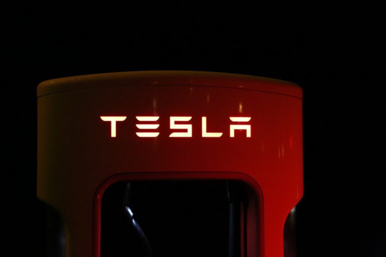 close-up-of-illuminated-text-of-Tesla-supercharger-against-black-background