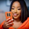 Picture of a woman wearing orange holding an orange HUAWEI Mate50 Pro